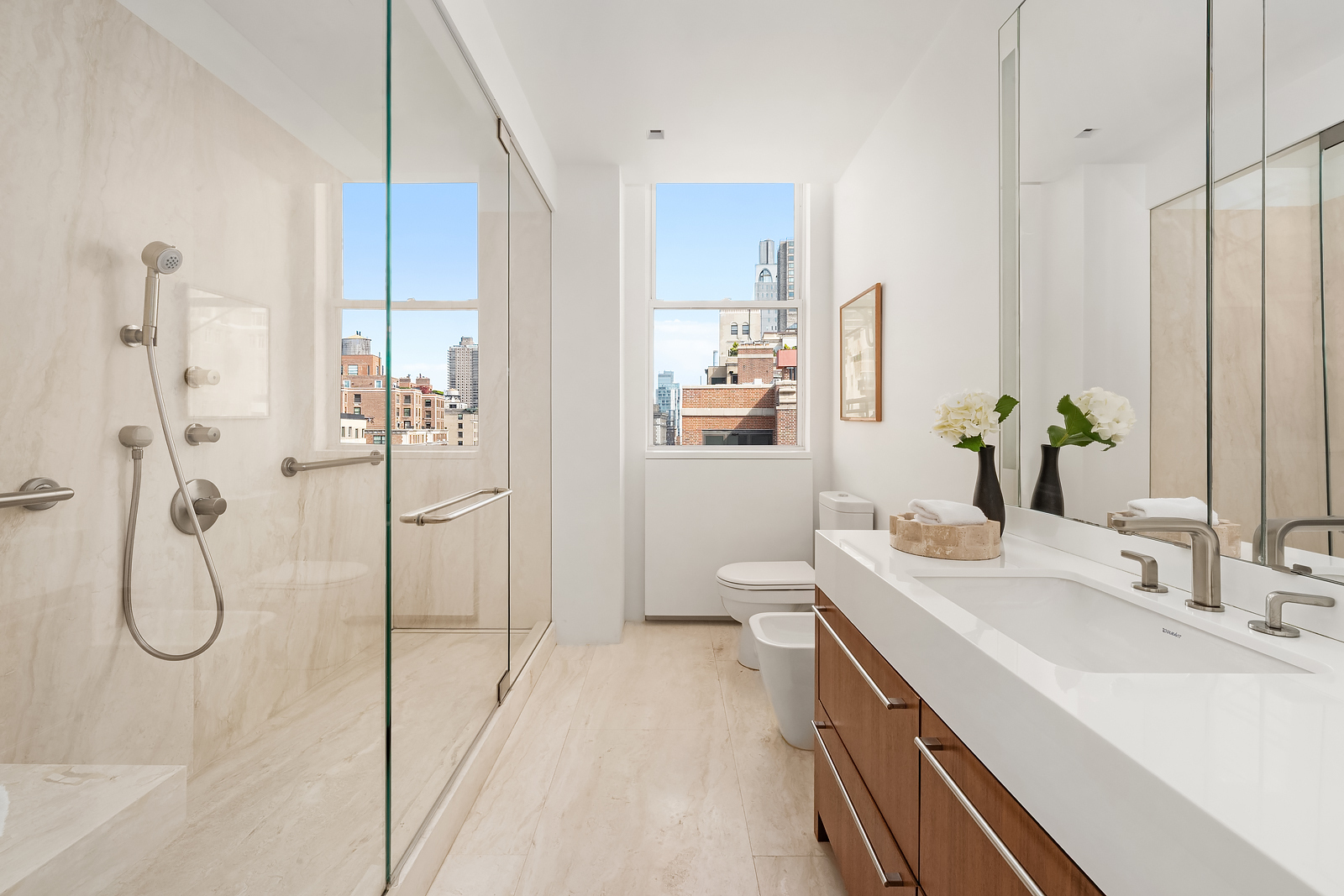 2 East 88th Street, Unit 11 Manhattan, NY 10128 - Photo 16 of 26 a bathroom with a double vanity sink a mirror and shower