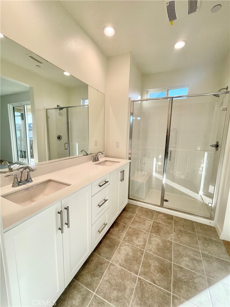 39396 Corvina Lane Temecula, CA 92591 - Photo 23 of 63 a spacious bathroom with a mirror a shower sink and vanity