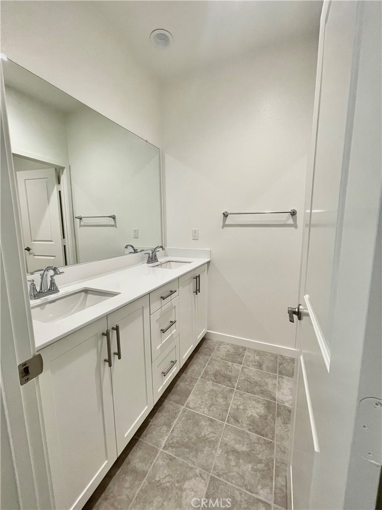39396 Corvina Lane Temecula, CA 92591 - Photo 36 of 63 a spacious bathroom with a double vanity sink a mirror and a shower