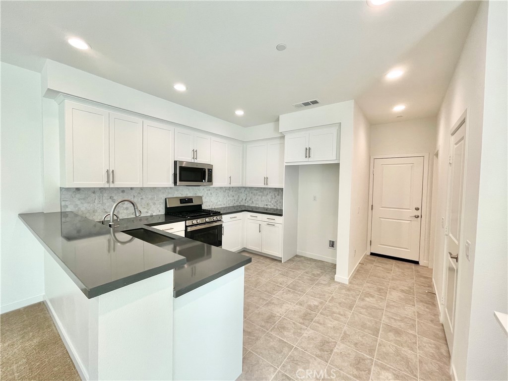 39396 Corvina Lane Temecula, CA 92591 - Photo 7 of 63 a kitchen with stainless steel appliances granite countertop a sink stove and refrigerator