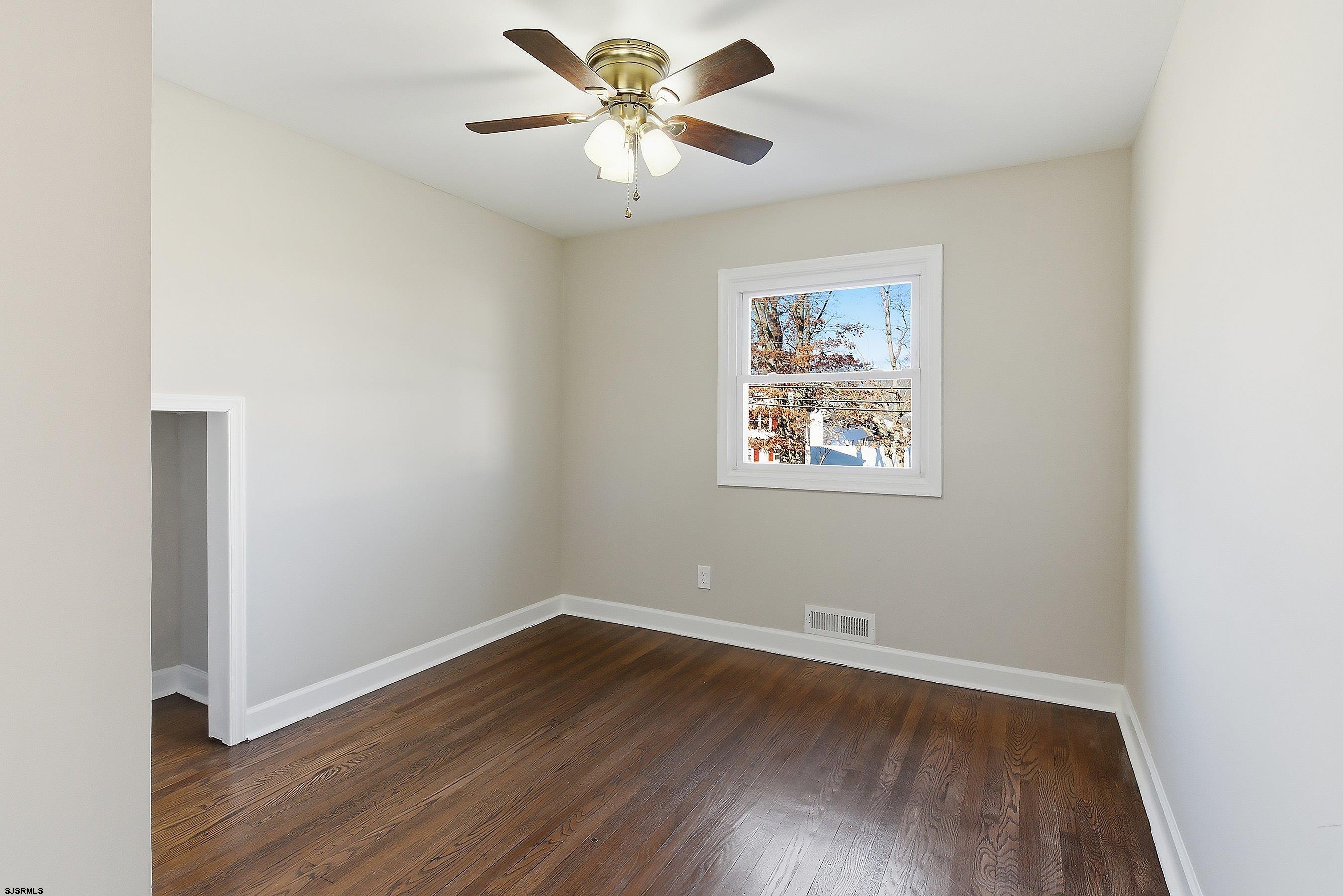183 Jordan Road Somers Point, NJ 08244 - Photo 22 of 42 an empty room with wooden floor and a ceiling fan