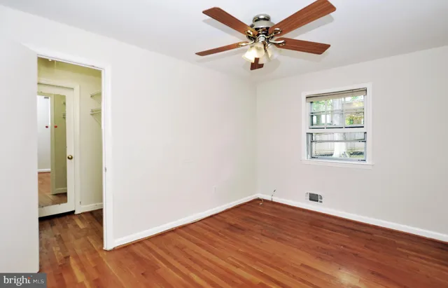wooden floor in an empty room with a window