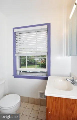 a bathroom with a sink a toilet and a window