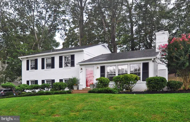 a front view of a house with a garden and plants
