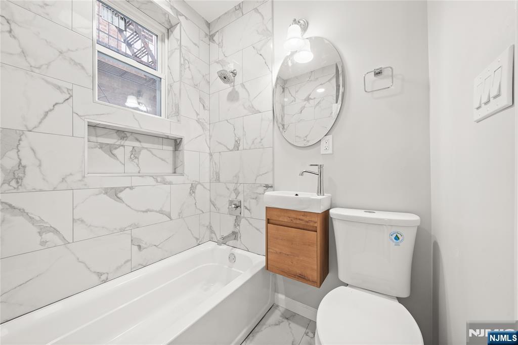 53 Henry Street, Unit D1 Passaic, NJ 07055 - Photo 13 of 16 a bathroom with a toilet a sink and bathtub