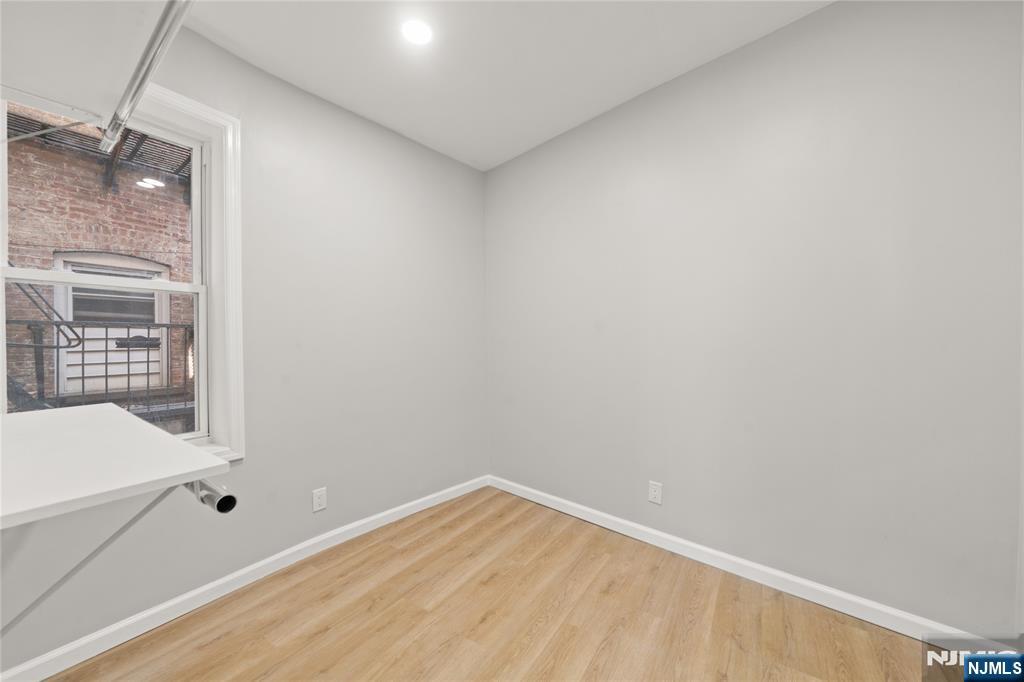 53 Henry Street, Unit D1 Passaic, NJ 07055 - Photo 14 of 16 a view of empty room with wooden floor and fan