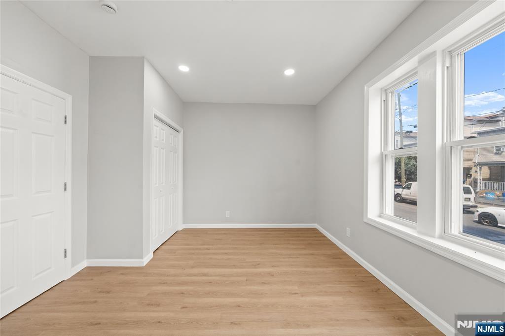 53 Henry Street, Unit D1 Passaic, NJ 07055 - Photo 2 of 16 a view of empty room with wooden floor and fan