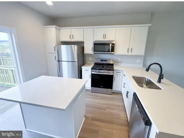 a kitchen with stainless steel appliances a refrigerator stove microwave and sink