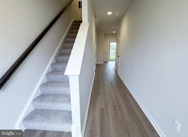 a view of entryway and hall with wooden floor