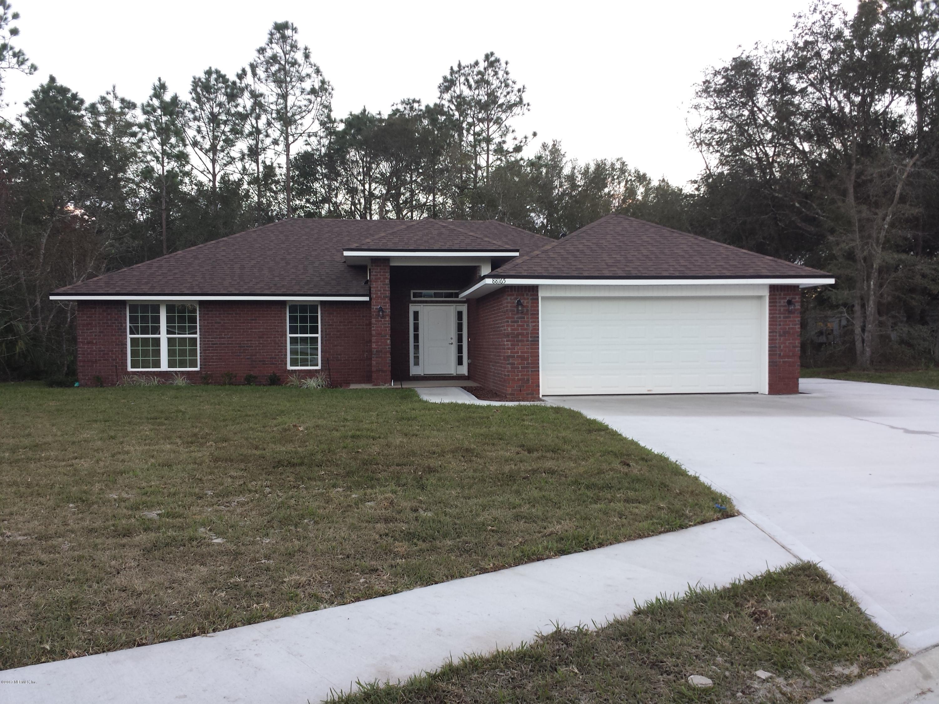 a front view of a house with a yard and trees