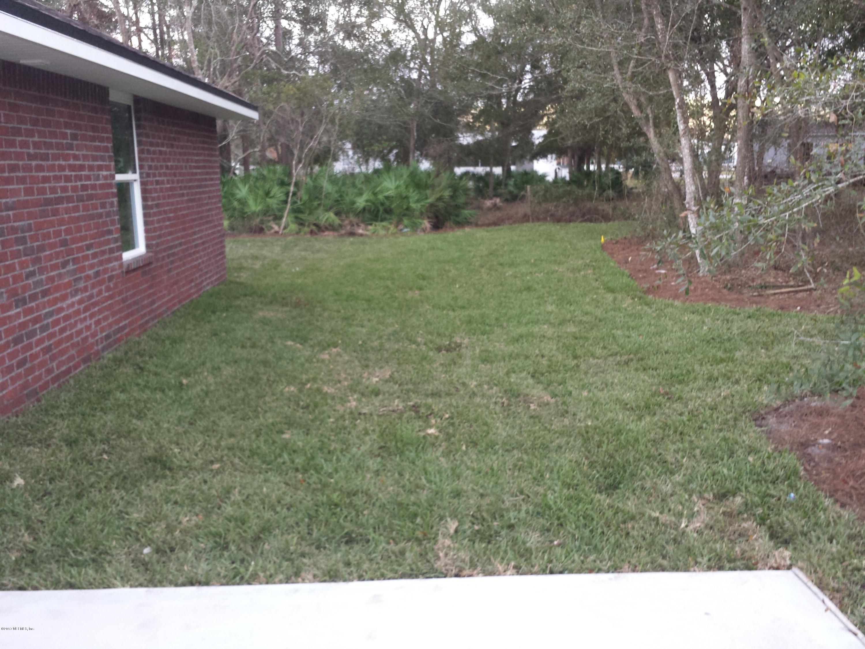 88165 Maybourne Road Yulee, FL 32097 - Photo 4 of 7 a backyard of a house with lots of green space