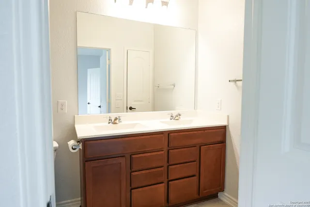 a bathroom with a double vanity sink and a mirror