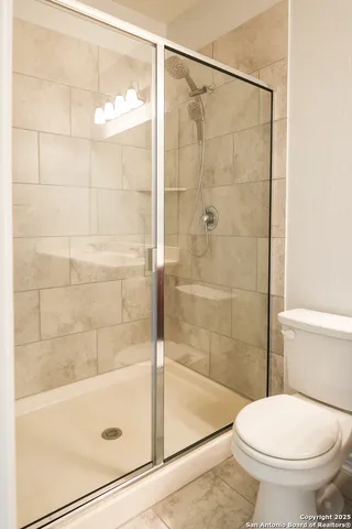 a bathroom with a toilet and a shower