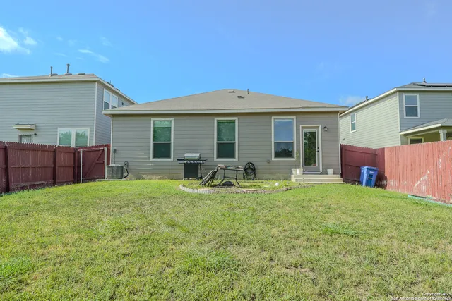 a view of backyard of house with wooden deck and seating space