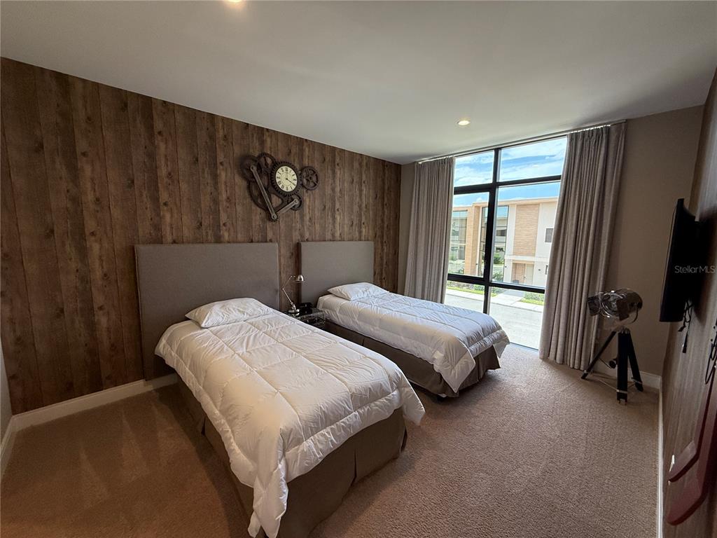 3065 Rockefeller Way Kissimmee, FL 34747 - Photo 32 of 59 a bedroom with two beds and a flat tv screen on dresser