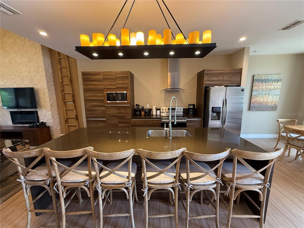 3065 Rockefeller Way Kissimmee, FL 34747 - Photo 6 of 59 a dining room with stainless steel appliances kitchen island granite countertop a dining table chairs and a refrigerator