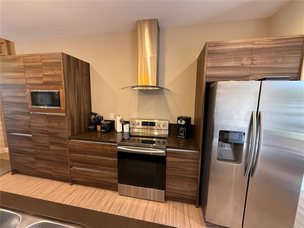 3065 Rockefeller Way Kissimmee, FL 34747 - Photo 8 of 59 a kitchen with stainless steel appliances a refrigerator and a stove