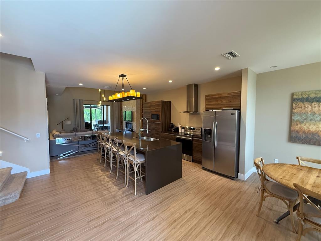 3065 Rockefeller Way Kissimmee, FL 34747 - Photo 9 of 59 a living room with furniture a dining table wooden floor and a view of kitchen