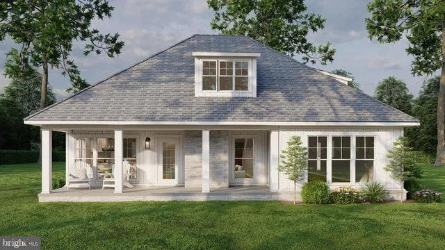 a view of a yard in front of a house with plants and large tree