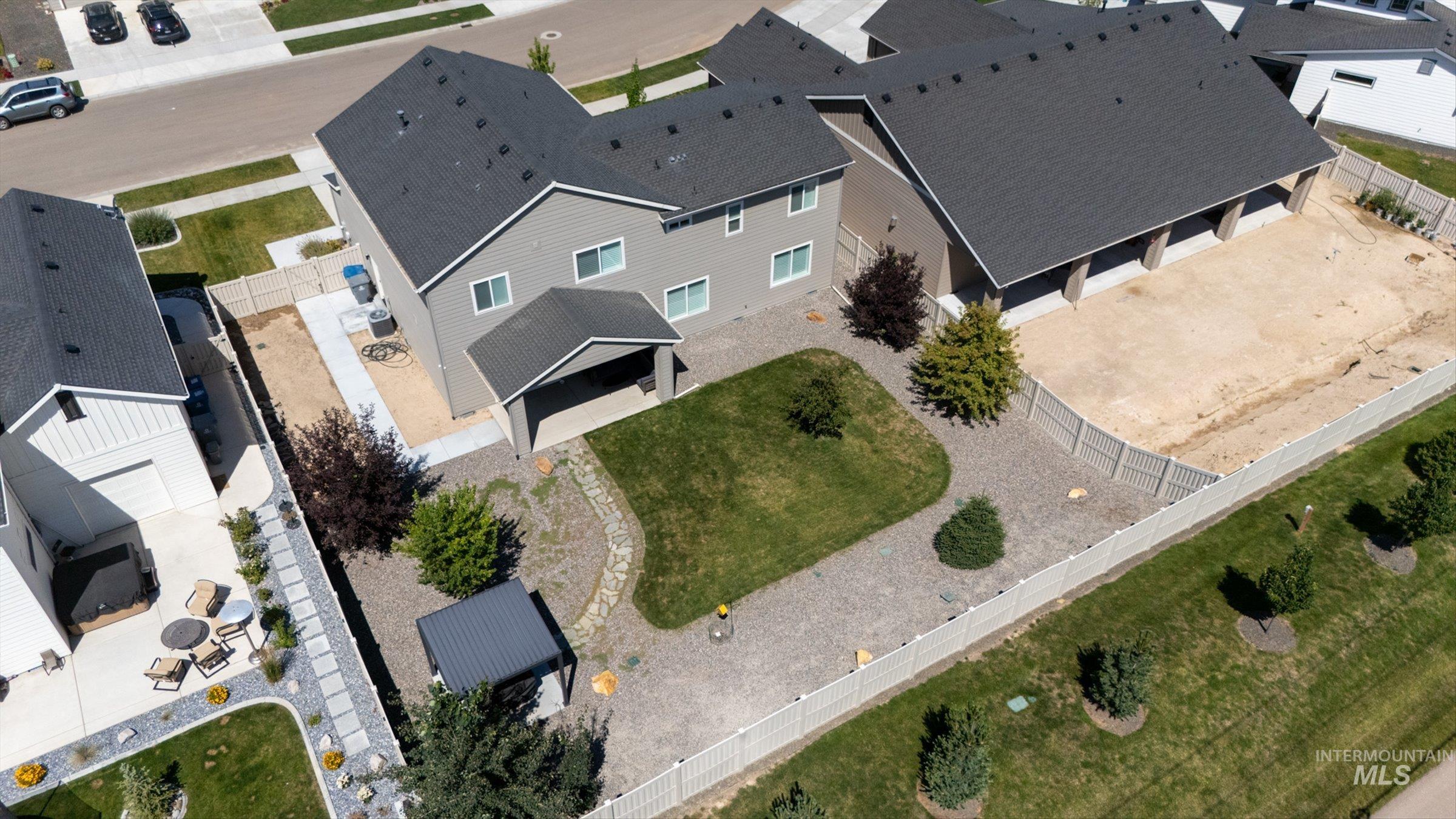 2172 Savoy Court Middleton, ID 83644 - Photo 42 of 46 Expansive rear yard featuring a covered patio, a manicured lawn, and a stone-paved walkway