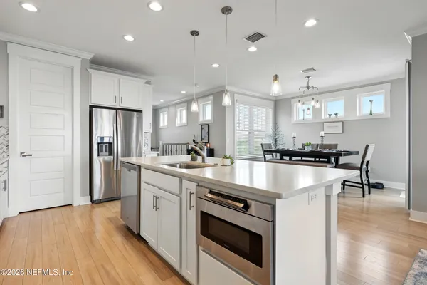 a large kitchen with lots of counter space a sink a dining table and chairs