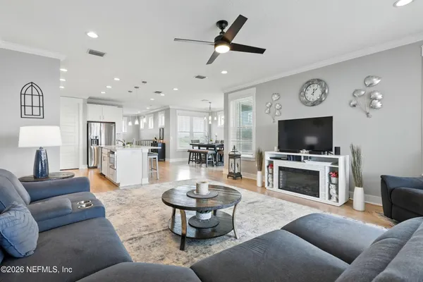 a living room with furniture a flat screen tv and a window