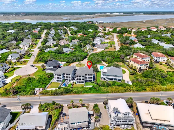 a city view with tall buildings and couple of cars parked in front of it