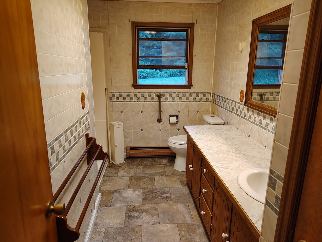 134 Railroad Street Oak Ridge, PA 16245 - Photo 10 of 20 a bathroom with a granite countertop sink a mirror and a bathtub