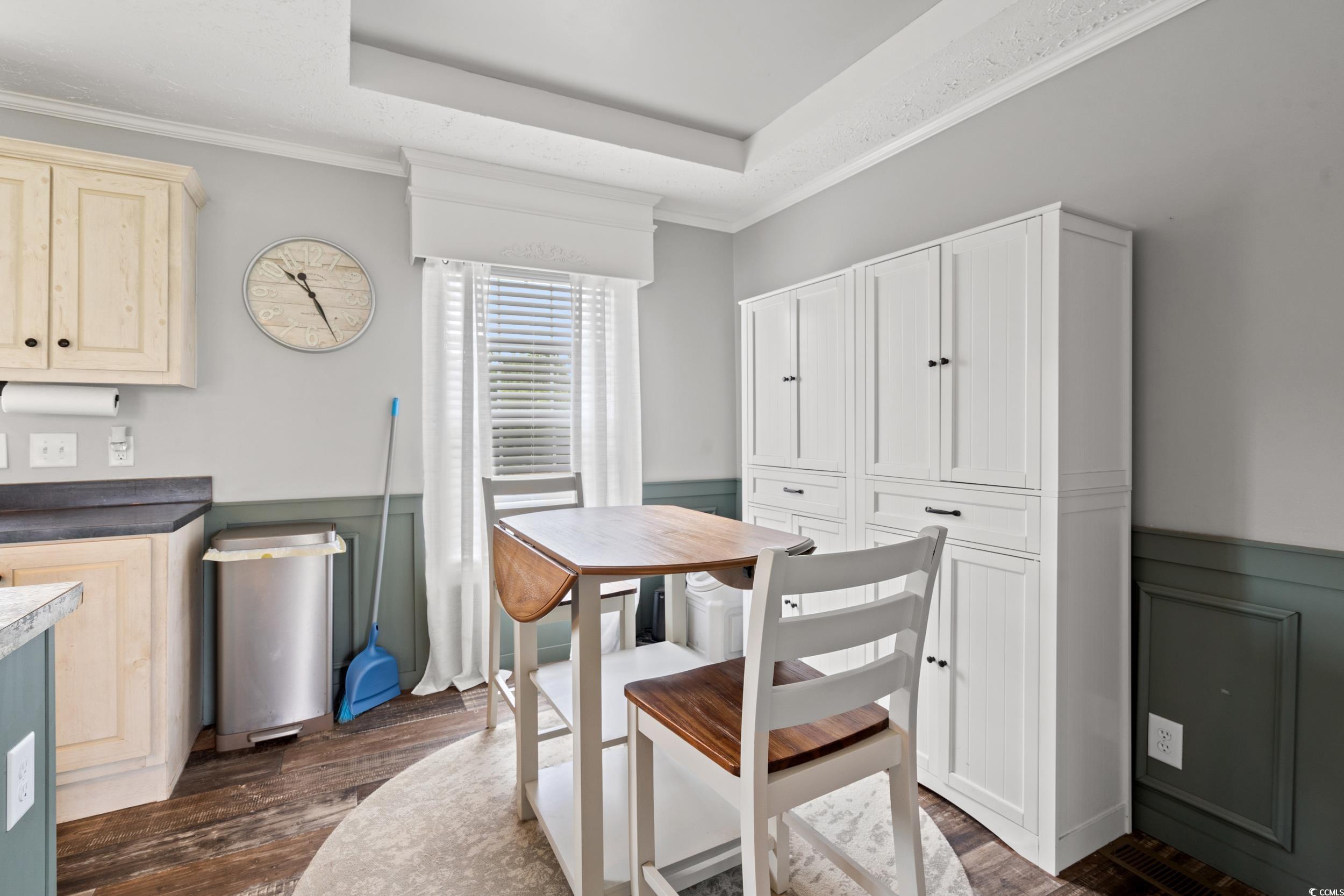 399 Calico Road Loris, SC 29569 - Photo 9 of 30 Dining space with dark wood finished floors, wainscoting, crown molding, and a raised ceiling