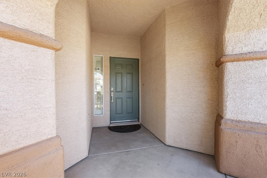 1007 Golden Ridge Court Henderson, NV 89052 - Photo 3 of 27 Textured stucco pillars frame a sheltered concrete entry leading to the front door.