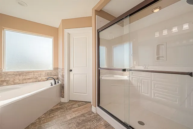 a bathroom with a tub shower and mirror