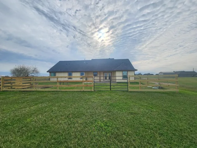 a view of a big house in a big yard with large trees