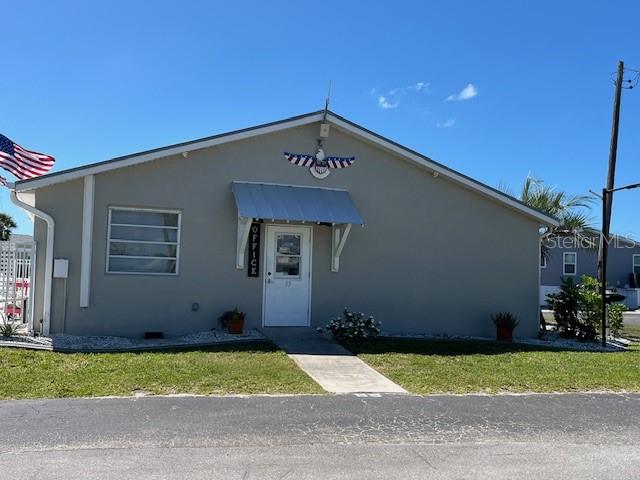 7500 Park Pointe Drive, Unit 42 Englewood, FL 34224 - Photo 27 of 33 a front view of a house with a yard
