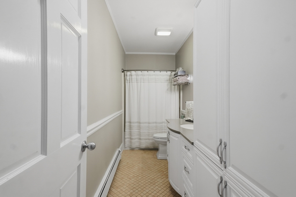 24 Minot Street Reading, MA 01867 - Photo 23 of 34 a bathroom with a double vanity sink a toilet and a bathtub