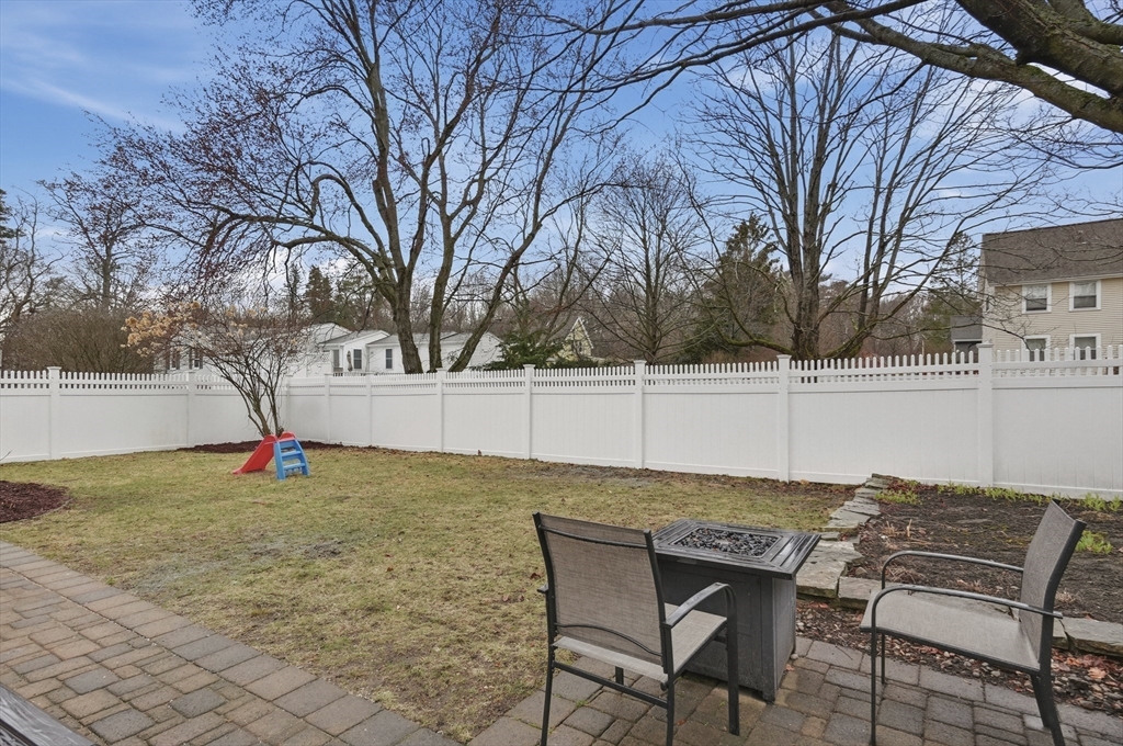 24 Minot Street Reading, MA 01867 - Photo 33 of 34 a backyard of a house with trampoline fire pit table and chairs