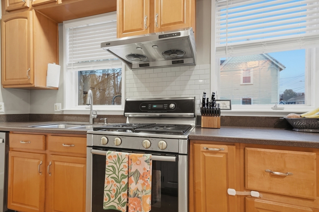 24 Minot Street Reading, MA 01867 - Photo 6 of 34 a kitchen with stainless steel appliances granite countertop a sink and cabinets