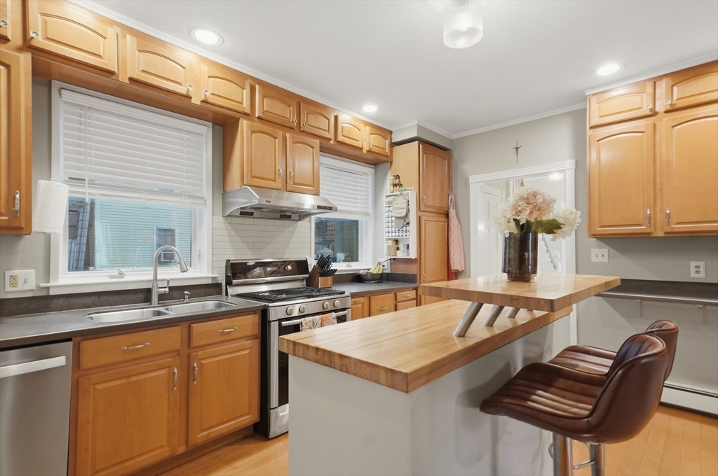 24 Minot Street Reading, MA 01867 - Photo 8 of 34 a kitchen with stainless steel appliances granite countertop a stove a sink and a refrigerator