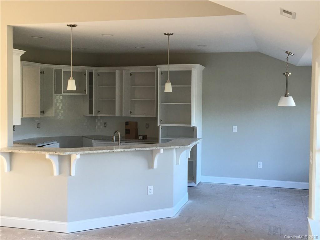 3115 East Brief Road, Unit 3 Monroe, NC 28110 - Photo 2 of 12 a kitchen with kitchen island a counter top space appliances and cabinets