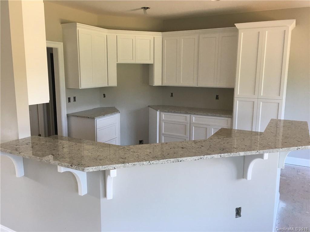 3115 East Brief Road, Unit 3 Monroe, NC 28110 - Photo 7 of 12 a kitchen with granite countertop a sink a stove and a granite counter tops