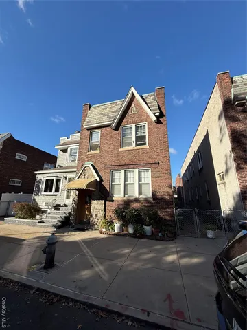 a front view of a house with cars parked