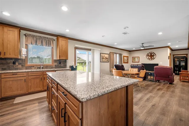 a kitchen with stainless steel appliances granite countertop sink stove dining table and chairs