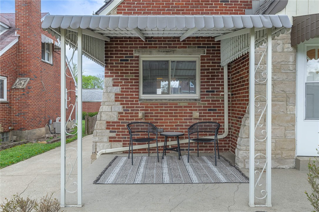 1012 Hampshire Road Dayton, OH 45419 - Photo 5 of 39 This inviting porch offers a delightful spot to unwind, featuring a classic brick exterior and an elegant awning.