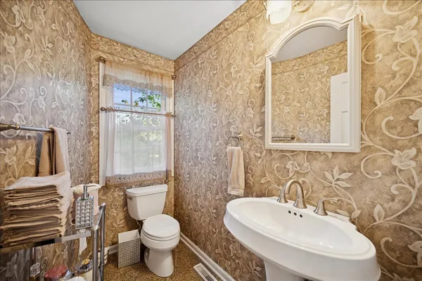 a bathroom with a toilet sink and mirror