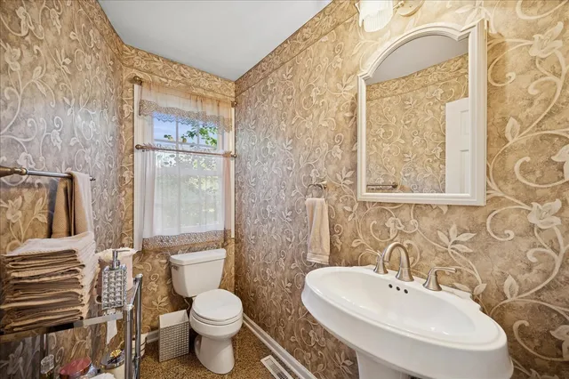 a bathroom with a toilet sink and mirror
