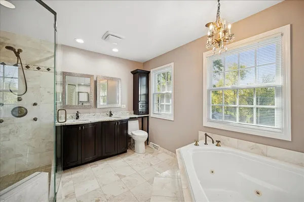 a spacious bathroom with a tub sink shower and mirror