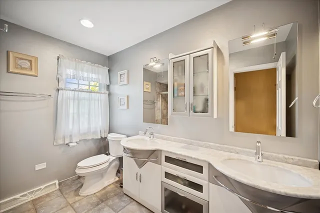 a bathroom with a sink a toilet and a large mirror