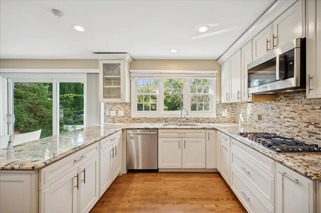 a large kitchen with stainless steel appliances granite countertop a stove and a sink