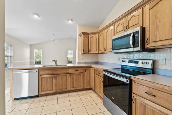 a kitchen with stainless steel appliances granite countertop a stove a sink and a microwave