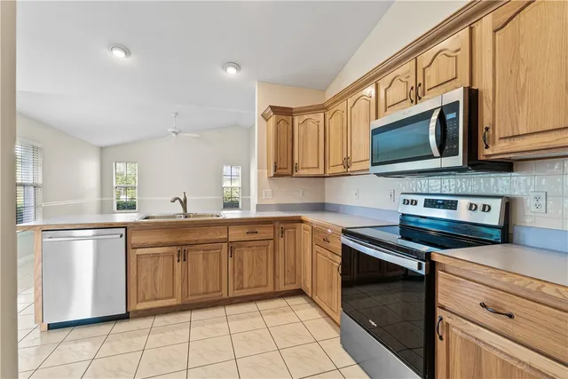 a kitchen with stainless steel appliances granite countertop a stove a sink and a microwave