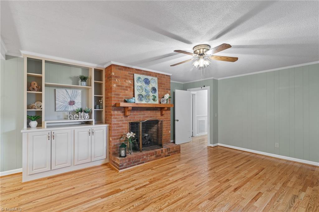1610 Bolingbroke Road High Point, NC 27265 - Photo 5 of 24 Gleaming HARDWOODS! Cozy Den off kitchen boasts built in shelving and Brick Fireplace